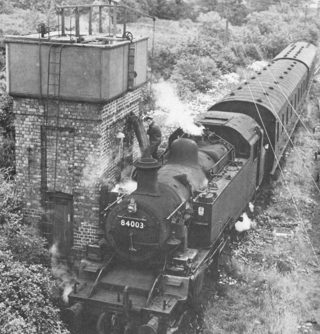 Designed at Derby and introduced in 1953, 84003 was a member of the smallest of British Standard 2-6-2T classes and owed much to the previous LMS Ivatt "Mickey Mouse" tank engines.  The top picture in this section shows it running chimney first with The Welsh Dragon past Foryd Junction, Rhyl, where the Ruthin branch diverged, on 6 August 1962.  In the middle is its push-pull set on Anglesea's Amwlch branch in March 1964 and the final picture, taken at the Amwlch water tank, dates from July 1964.