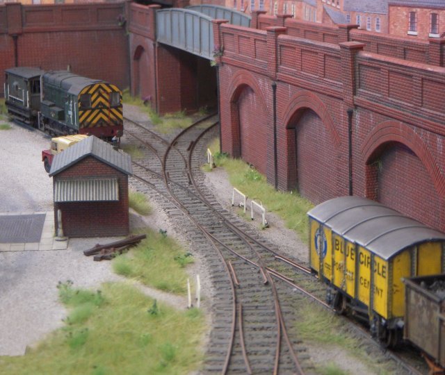 The design - controlled by DCC or analog systems - was based on an Inglenook Shunting Puzzle and carefully design to allow the use of a Class 20 or Class 25 diesel.  The track was hand built using SMP parts with wye points of differing radii mounted on timber offcuts which only cost � 9.00.  Two sets of mostly Bachmann rolling stock were used, one with modified hands-free couplings and the other with 3mm finescale Sprat and Winkle couplings.