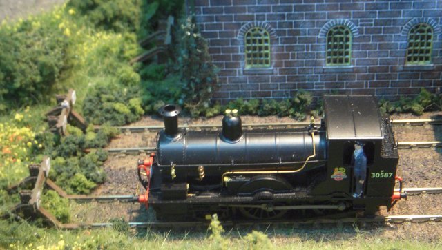 Set in Devon between 1948 and early 1960s and separated from a fictional station - really a fiddle yard - by a bridge, 8' x 2' Yard Shunter saw train engines being released by the eponymous fixed wheelbase locomotives - ranging from a sound fitted BR 08 to a Beattie Well Tank - and the wagons destined for a private timber merchant, goods shed, coal merchants and cattle pen being re-arranged.  Points on the C&L hand built wooden sleeper track were worked by under-board servo point operation controlled ultimately via MERG servo 4 and accessory decoder.  Meanwhile NCE PowerCab DCC also controlled ex Southern Railway N and Q1 Class locomotives as well as a Standard 4MT 2-6-4T.