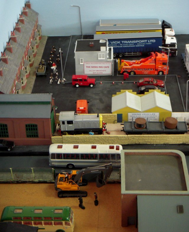 Inspired by the one time favourite adjective of glamour model Katie Price, "Ming Ing" - which splits into a Chinese dynasty and an old English word for low lying grassland prone to seasonal flooding - depicted York's fictional Chinatown district and included York's city walls, the canalised River Foss, a Derwent Valley Light Railway resurgent in the Twenty First Century, a terraced street, garage, lorry park and transport cafe and depot for cleaning repairing, refuelling coaches that have just brought tourists to York Minster, the National Railway Museum and Jorvik Viking Centre.  Also visible on Ming Ing's first outing was the York and Ainsty Hunt chasing a fox run over by a Class 04 shunter, a workman attempting to repair the engine of a Volvo excavator with an axe and, thanks to Andy Peckham, a Volvo B9M short-chassis coach with a Plaxton Premiere body from his Black and White fleet.