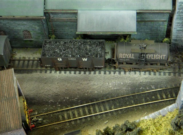 The Coal Yard represented a small corner of a colliery with a working loader, allowing a train of empty wagons to arrive from the exchange sidings and for the railway company locomotive to be uncoupled before a colliery shunter propelled them under the loader.  The full wagons were then returned to the siding they had arrived on, the shunter retired to its own engine shed and the train engine re-attached to take them away.