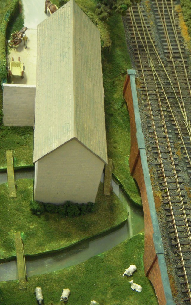 This fictitious 1950s layout was based on the concept that the Midland & South Western Junction Railway continued as a secondary route through the Cotswolds despite the Great Western Railways endeavours to rationalise it during previous years.  Trains of former LMS and GWR stock could thus be seen on the 11'6" long by 20" scenic section between fiddle yards.