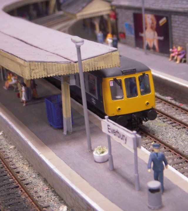 I particularly enjoyed the lighting and composition on the shot above, with the front of the first generation DMU and platform canopy end on the focal plane and the girl in the white dress just to their left being given a painterly, Jack Vettriano type illumination.  Just as on Terminal 1, an advertisement featuring Eva Herzigova helps establish the limits of the background.