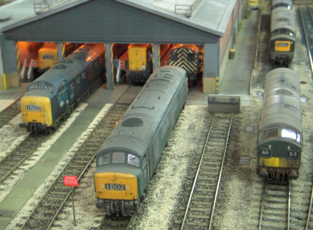 Hornsey Broadway was based on North London circa 1970 and - when fully assembled - would have featured a section of main line with adjacent locomotive depot within its 24' x 3' scenic section, which would also have presented the differing track levels and flyover typical of the route north from King's Cross which allowed slower trains to cross the main lines without interruption.  C&L track and copper clad pointwork were used on the open frame plywood baseboards, and even just the locomotive depot module as seen at St Margaret's Hall immediately evoked the "Get Carter" era of blue and green diesels built at Derby, Rugby, Newton-le-Willows and Glasgow.  The red signs instructed drivers not to pass them unless the shed doors were open, or as Michael Caine might have put it, "You're a big locomotive but you're out of condition.  With me it's a full time job, now behave yourself!"
