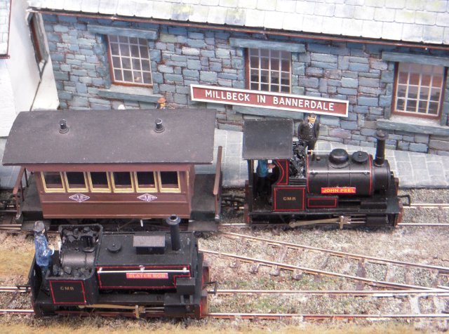 Using 00 (16.5mm) Peco gauge track to represent a narrow gauge in the 7mm scale originally associated with 7mm (1/43 scale) model railways, the fictional Cumberland Mineral Railway operated in a quiet corner of the northern Lake District, transporting slate, coppiced timber, bobbins from a mill, general merchandise and passengers from Millbeck in Bannerdale to a junction with the main line at Greystoke.  In the years following the closure of the Cumberland Mineral Railway Bannerdale was flooded to create Bannermere Reservoir.