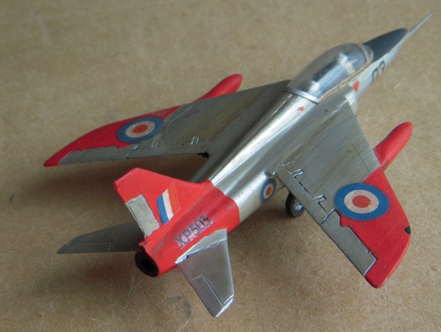 Although passed over in favour of further development of the Hawker Hunter as a de Havilland Venom replacement, the Folland Gnat was further investigated by the RAF as a two seat trainer to bridge the gap between the de Havilland Vampire T11 and the English Electric Lightning.  The resulting prototype, XM691, was thus built to Air Ministry Specification T185 and first flown on 31 August 1959 and featured thinner wings, Folland's own design of lightweight ejector seats and a more conventional arrangement of outboard ailerons and conventional flaps.  The location of this first flight was Chilbolton, Hampshire although the pilot for both this and the first flight of the Midge five years earlier was Squadron Leader E.A. "Teddy" Tennant.