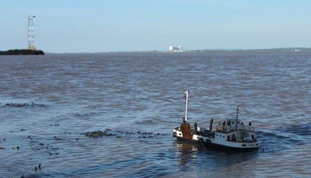 Looking upstream this time, Ian's Severn King is about to sail into sunlight with Oldbury nuclear power station on the horizon above its mast and the lighthouse guarding the Hen and Chickens rocks to the left of the picture.
